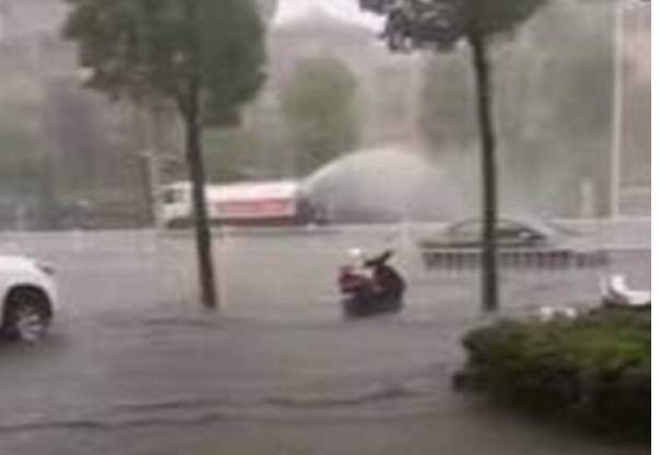 河南洒水车暴雨中